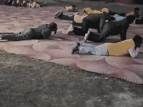 धमाकों की गूंज के बीच जमीन पर लेटे लोग